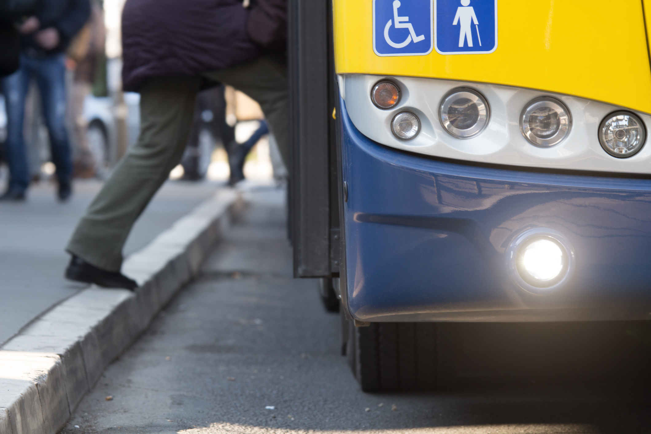 A man steps onto a bus on a busy street